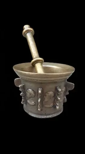 Almirez antiguo de bronce con su mano, pieza valorada por un tasador de antigüedades