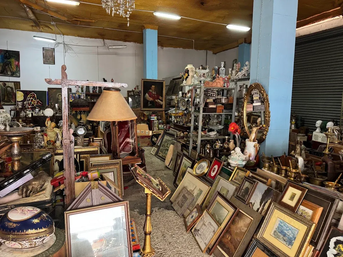 Interior de Antigüedades Miguel, anticuario en Zaragoza: cuadros, espejos dorados, lámparas, porcelana y bronces