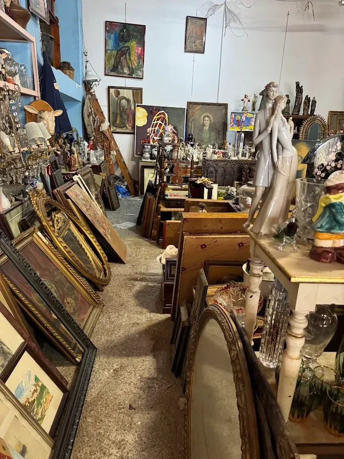 Pasillo de la tienda de antigüedades en Zaragoza con cuadros, espejos dorados y figuras