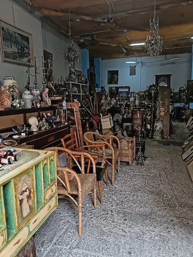 Pasillo de la tienda de antigüedades en Zaragoza con sillas, muebles y lámparas